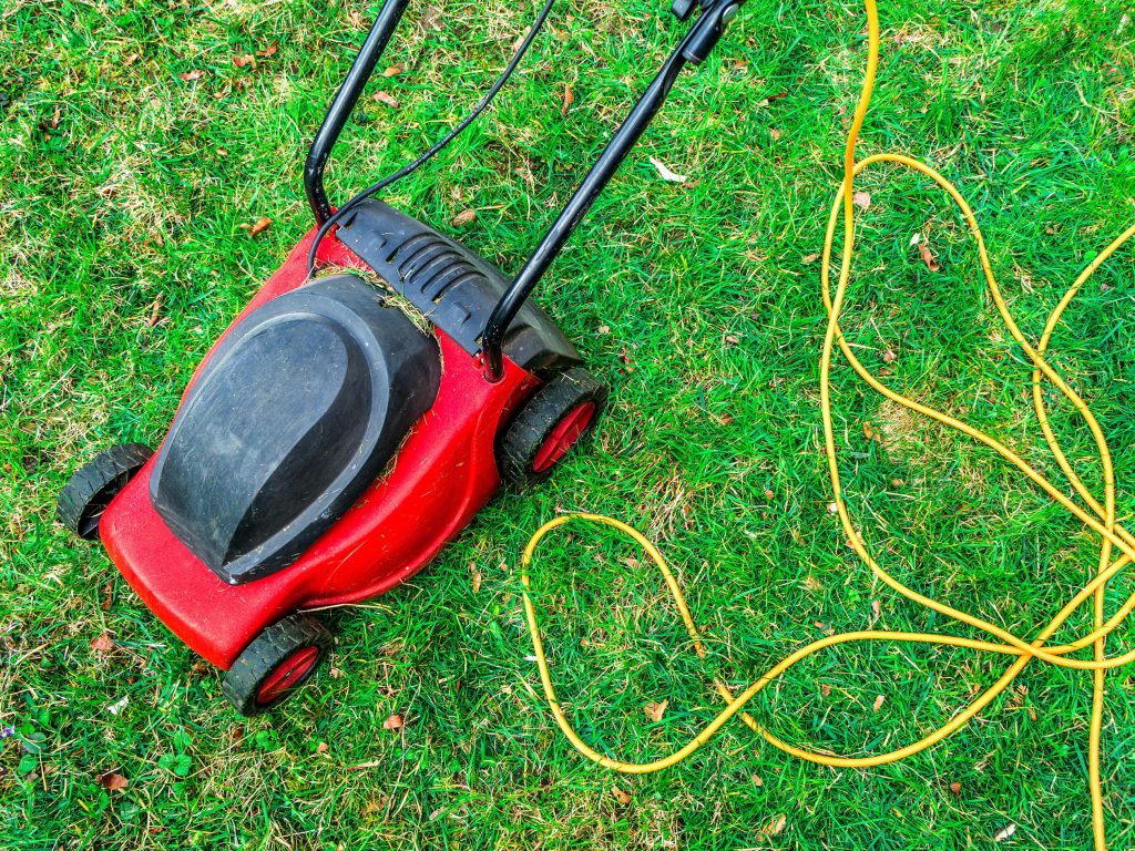 Corded lawn mower on grass.