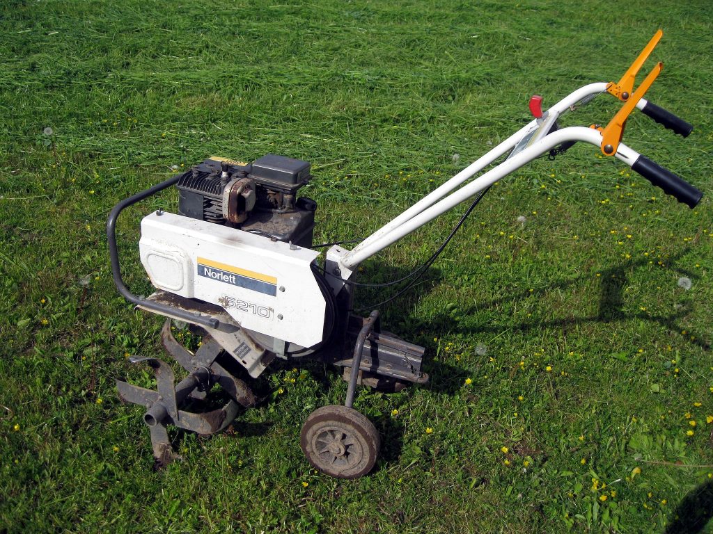 Garden tiller on grass.