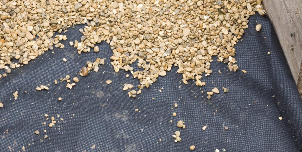 Gravel on top of a weed membrane.