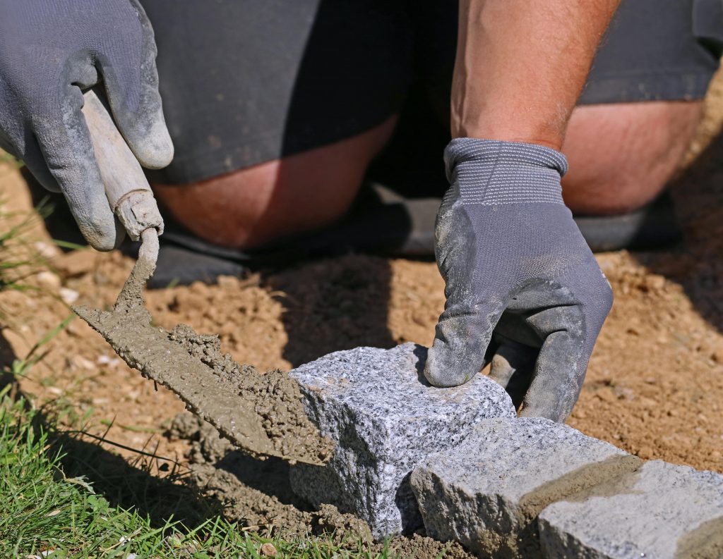 Laying bricks to create a lawn edge.