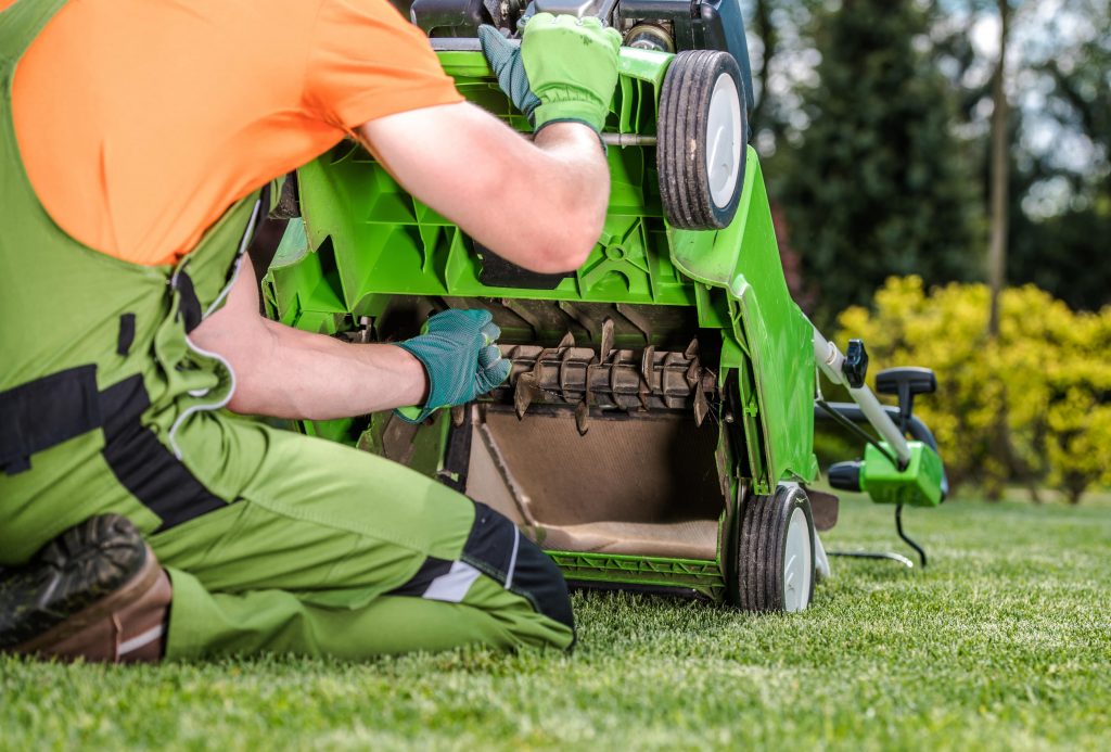 Man adjusting the cassette on a lawn scarifier.