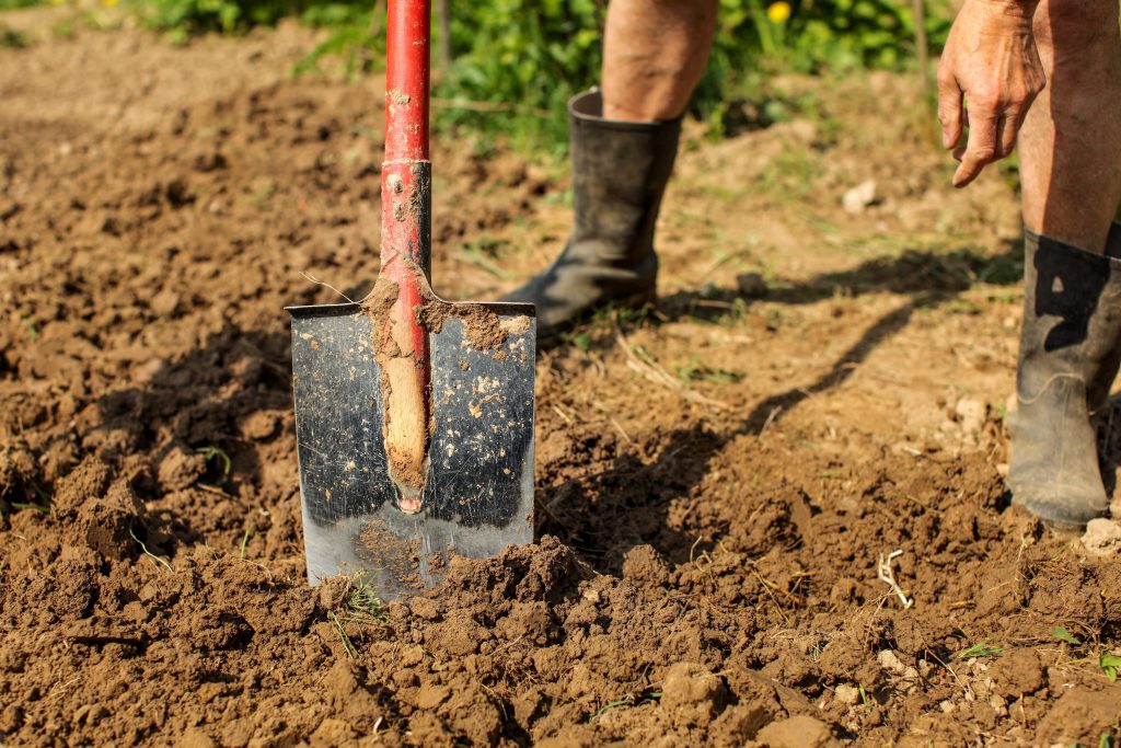 Man digging in clay soil.