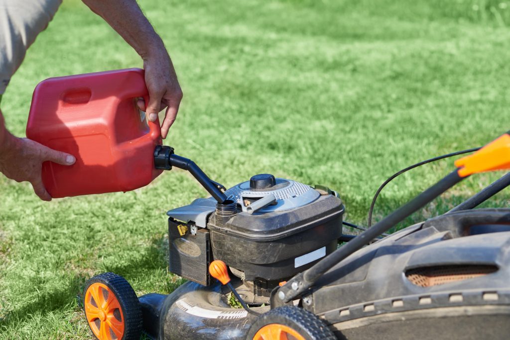 Man refueling lawn mower.