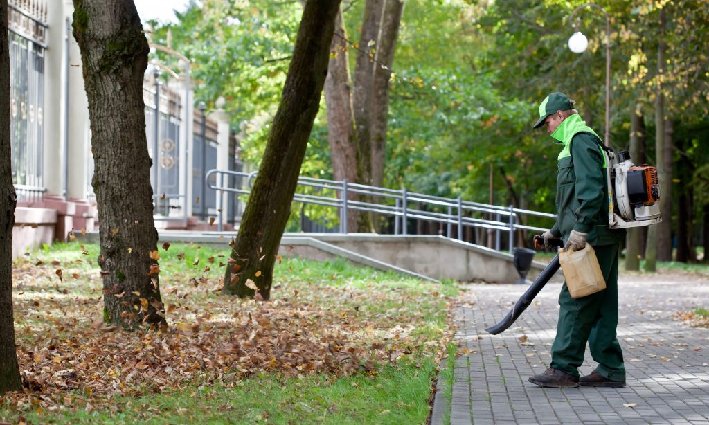 Man using a backpack leaf blower.