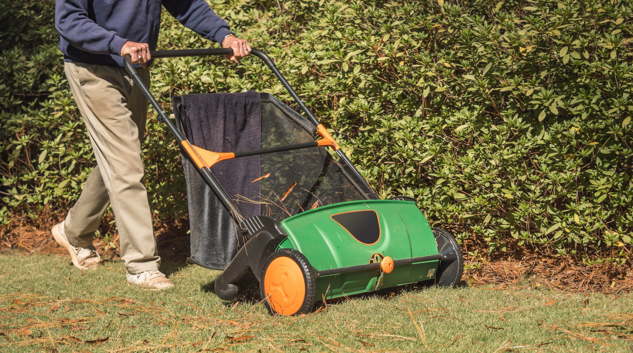 Man using a lawn sweeper.