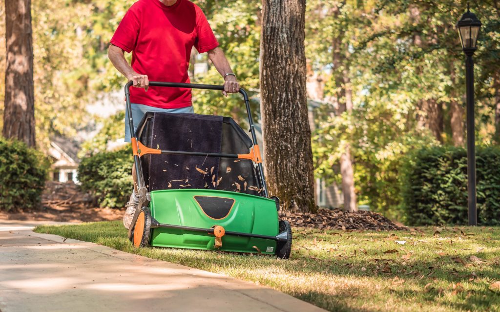 Man using a lawn sweeper.