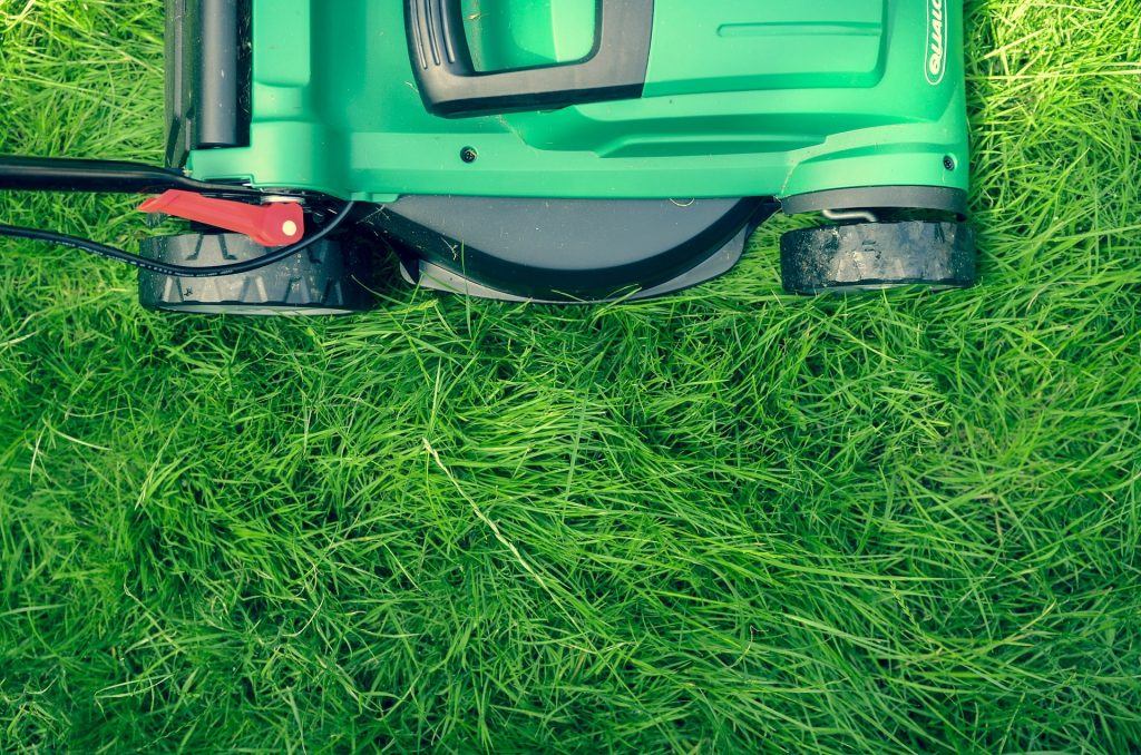 Corded lawn mower cutting grass.