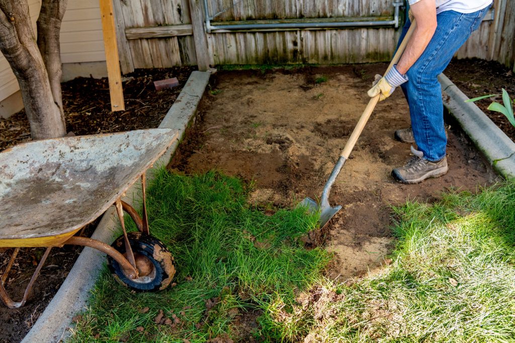 Person removing sod and placing it in a wheelbarrow.