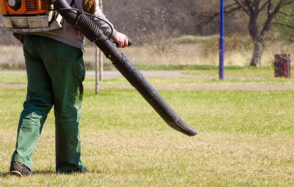 Person using a petrol leaf blower.