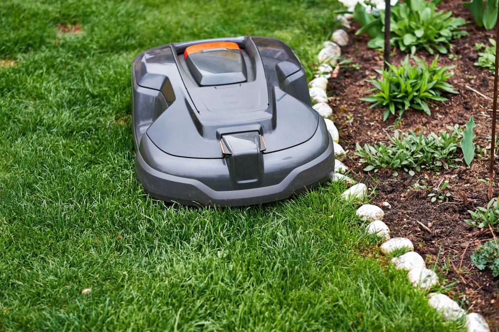 Robotic lawn mower cutting the edge of a garden.