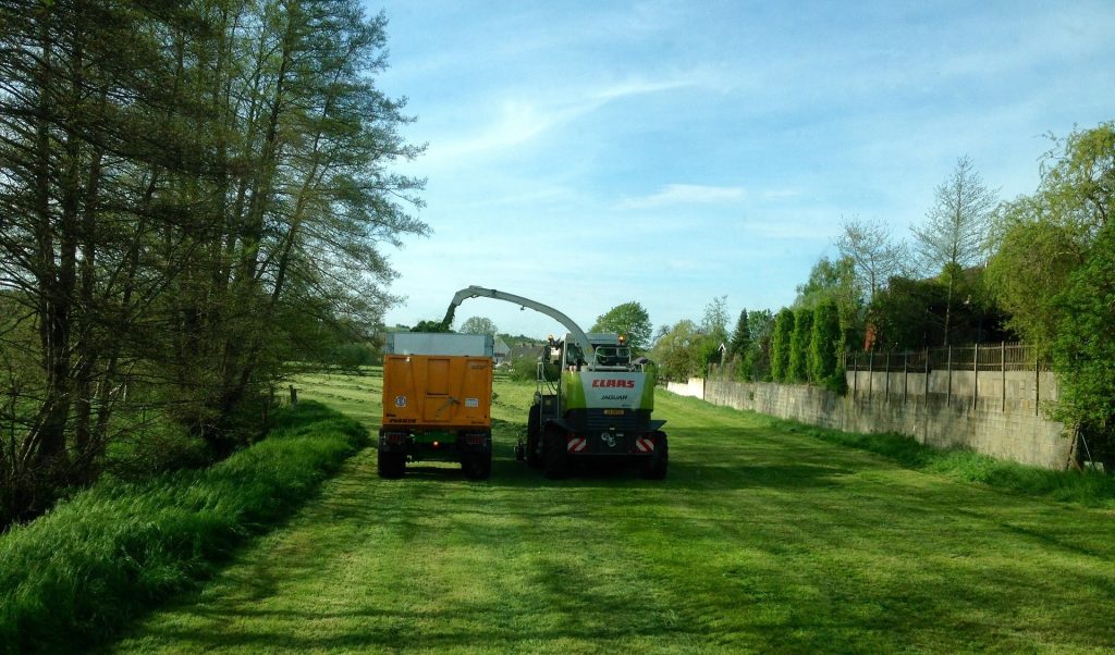 Tractor collecting grass clippings.