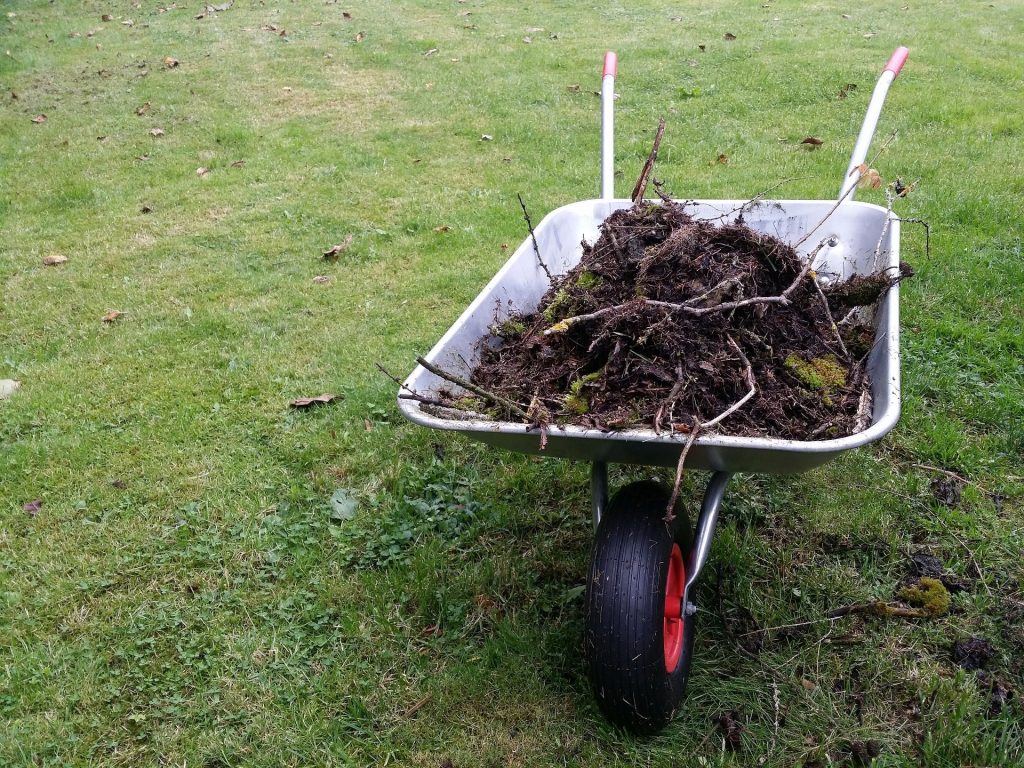 Wheelbarrow full of logs and dirt.