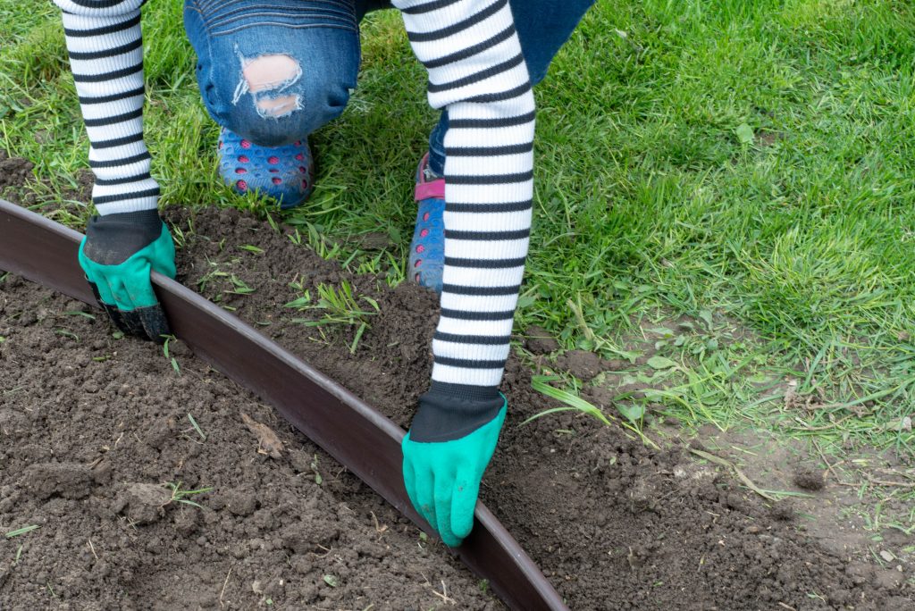 Woman installing a grass edge barrier.